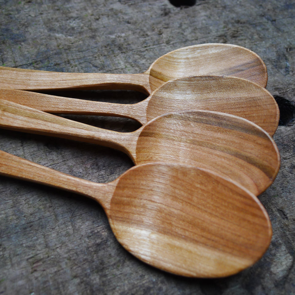 Close up image of the bowls of four wooden eating spoons